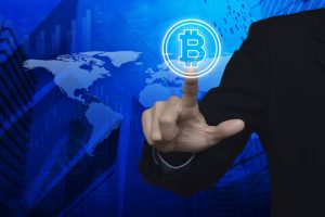 crte monde, doigt sur logo bitcoin